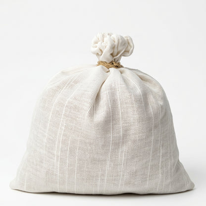 A cream-colored linen drawstring bag with a textured vertical weave, tied at the top with a natural jute rope, set against a plain white background.