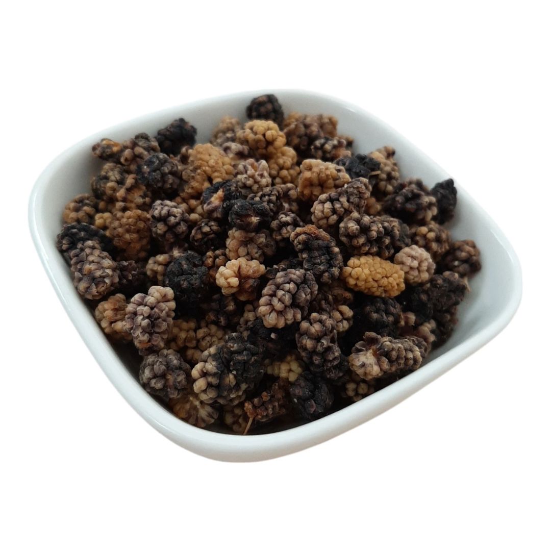 White bowl filled with dried black and brown mulberries on a white background. This kala shahtoot are from Chitral Valley